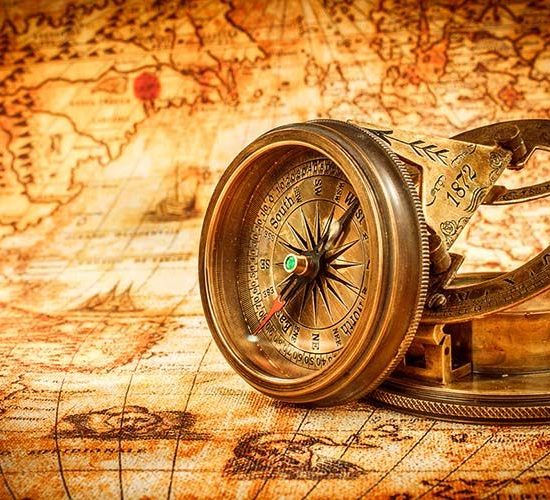 Vintage compass lies on an ancient world map. Vintage still life. Vintage compass lies on an ancient world map in 1565.